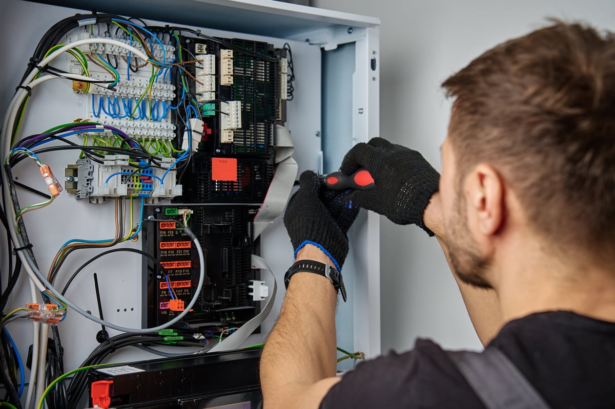 Técnico revisando el cableado interno de un sistema de bomba de calor